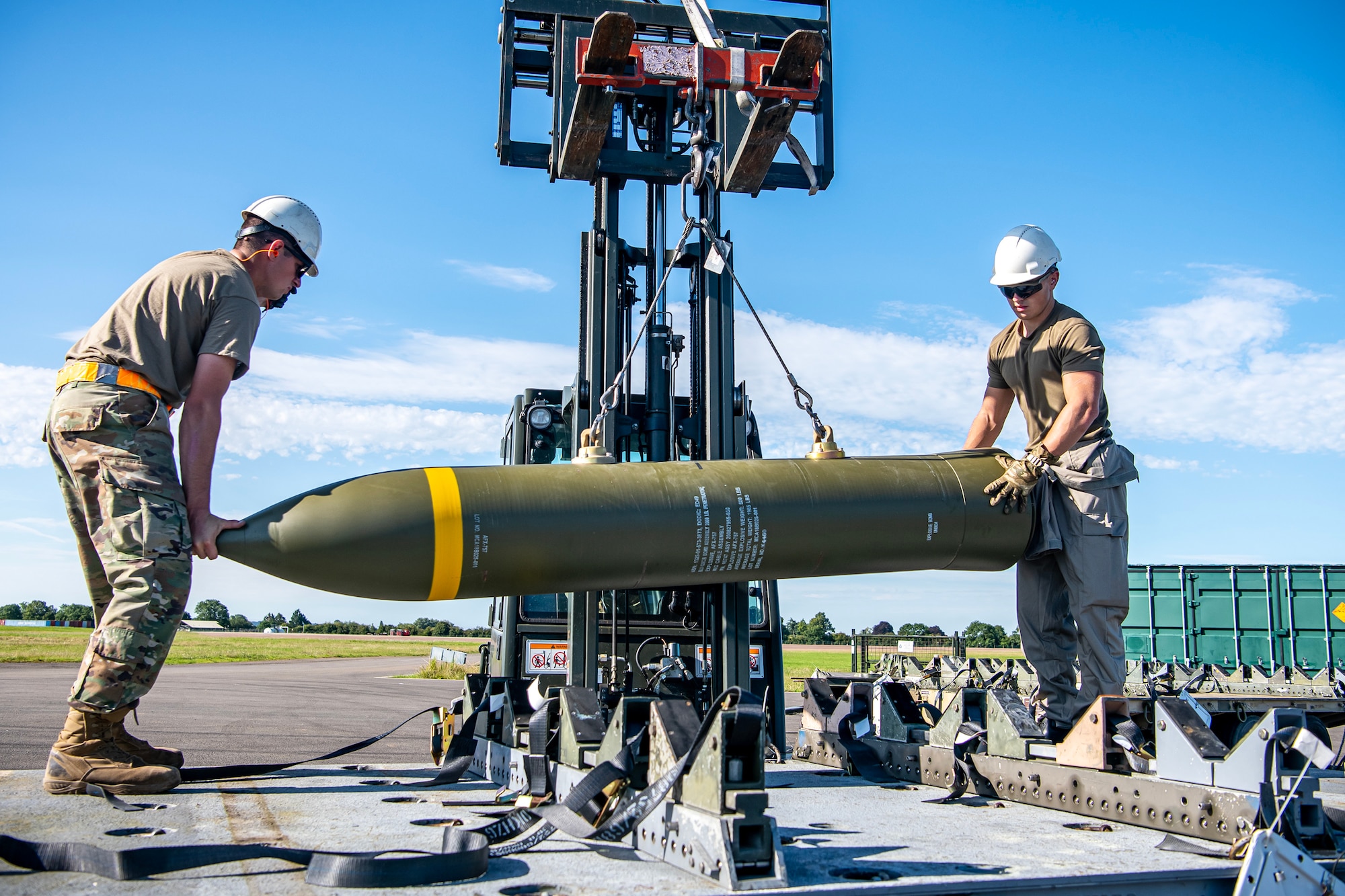 Members from the U.S. and Royal Air Force transport a muntion at RAF Fairford, England, Aug.10, 2023. Members from the 48th FW, 501st Combat Support Wing, 28th Bomb Wing and Royal Air Force conducted munitions builds and transports in support of a week-long Combat Ammunition Production Exercise. The exercise provided them an opportunity to evaluate munitions combat readiness, base support plan adequacy, tactics, techniques and procedures and enhanced interoperability between NATO forces. (U.S. Air Force photo by Staff Sgt. Eugene Oliver)