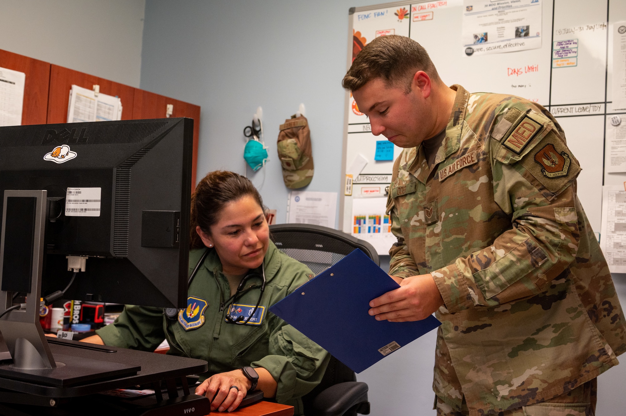 A provider and medical technician discuss a patient.