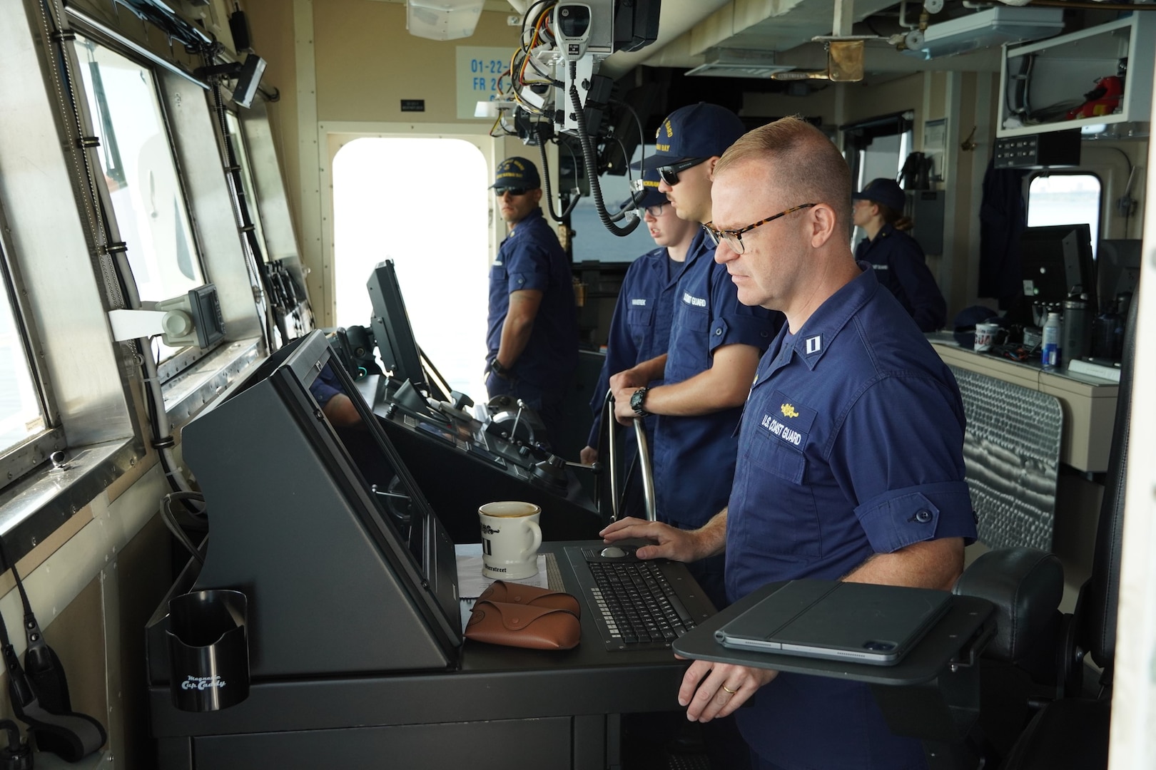 Lt. Michael Overstreet and Coast Guard personnel at the controls of United States Coast Guard Cutter Katmai Bay during the 2023 Chicago Yacht Club Race to Mackinac. (U.S. Coast Guard Auxiliary photo courtesy of John Saran, Auxiliary Public Affairs Specialist 1)