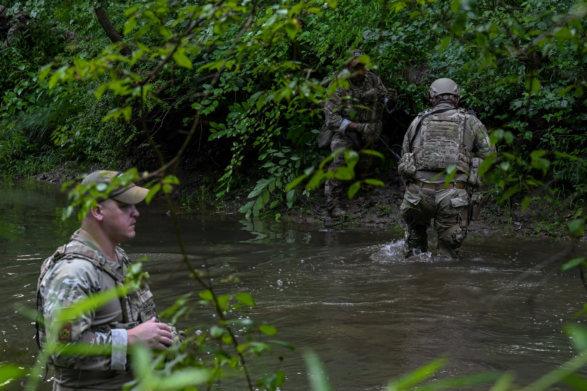 Tech. Sgt. Daniel Ayers, a Defender assigned to the North Carolina Air National Guard's 145th Security Forces Squadron, walks through a stream during an Integrated Defense Leadership Course training exercise on July 27, 2023, at Camp James A. Garfield Joint Military Training Center, Ohio.