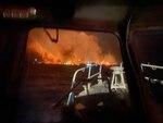 The view from a Coast Guard vessel sailing at night as a wildfire burns in the distance.
