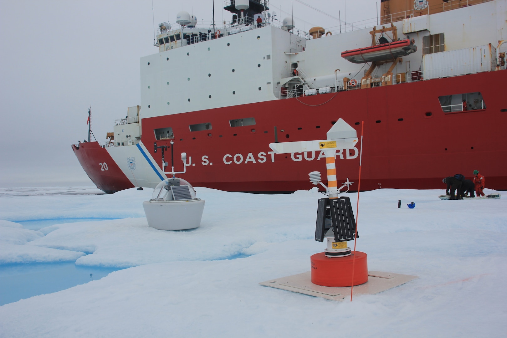 Researchers monitor and set up science instruments to begin data collection on an ice floe next to U.S. Coast Guard Cutter Healy (WAGB 20) in the Beaufort Sea, Aug. 6, 2023. The objectives included the installation of two major instruments: the Waves, Weather, Ice Mass, Balance, and Ocean (WIMBO) device, a massive weather buoy destined to remain at sea; and a Dynamic Ocean Topography device, collecting sea surface data. Science instruments like the WIMBO are individual components of a greater project, the Arctic Mobile Observing System (AMOS), a network of robotic oceanographic instruments making years-long autonomous observations of ocean and sea ice physics.  (Coast Guard photo by Ensign Zane Miagany)