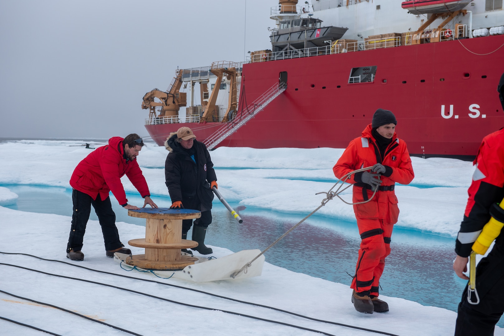 A team of researchers moves equipment across an ice floe to an installation site in the Beaufort Sea, Aug. 9, 2023. Healy is the Coast Guard’s only icebreaker specifically designed for Arctic research, as well as the nation’s sole surface presence routinely operating in the Arctic Ocean. (Coast Guard photo by Petty Officer 3rd Class Briana Carter)