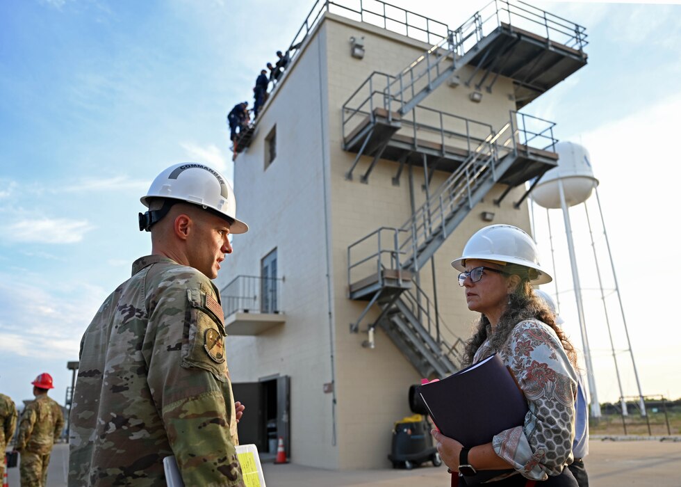 U.S. Air Force Lt. Col. Branden Delong, 312th Training Squadron commander, and Dr. Wendy Walsh, Air Education and Training Command chief learning officer, discuss the repelling course at the Louis F. Garland Department of Defense Fire Academy, Goodfellow Air Force Base, Texas, Aug. 8, 2023. The repelling follow-on course teaches students how to save people from steep cliffs, tall buildings, and waterways. (U.S. Air Force photo by Senior Airman Sarah Williams)