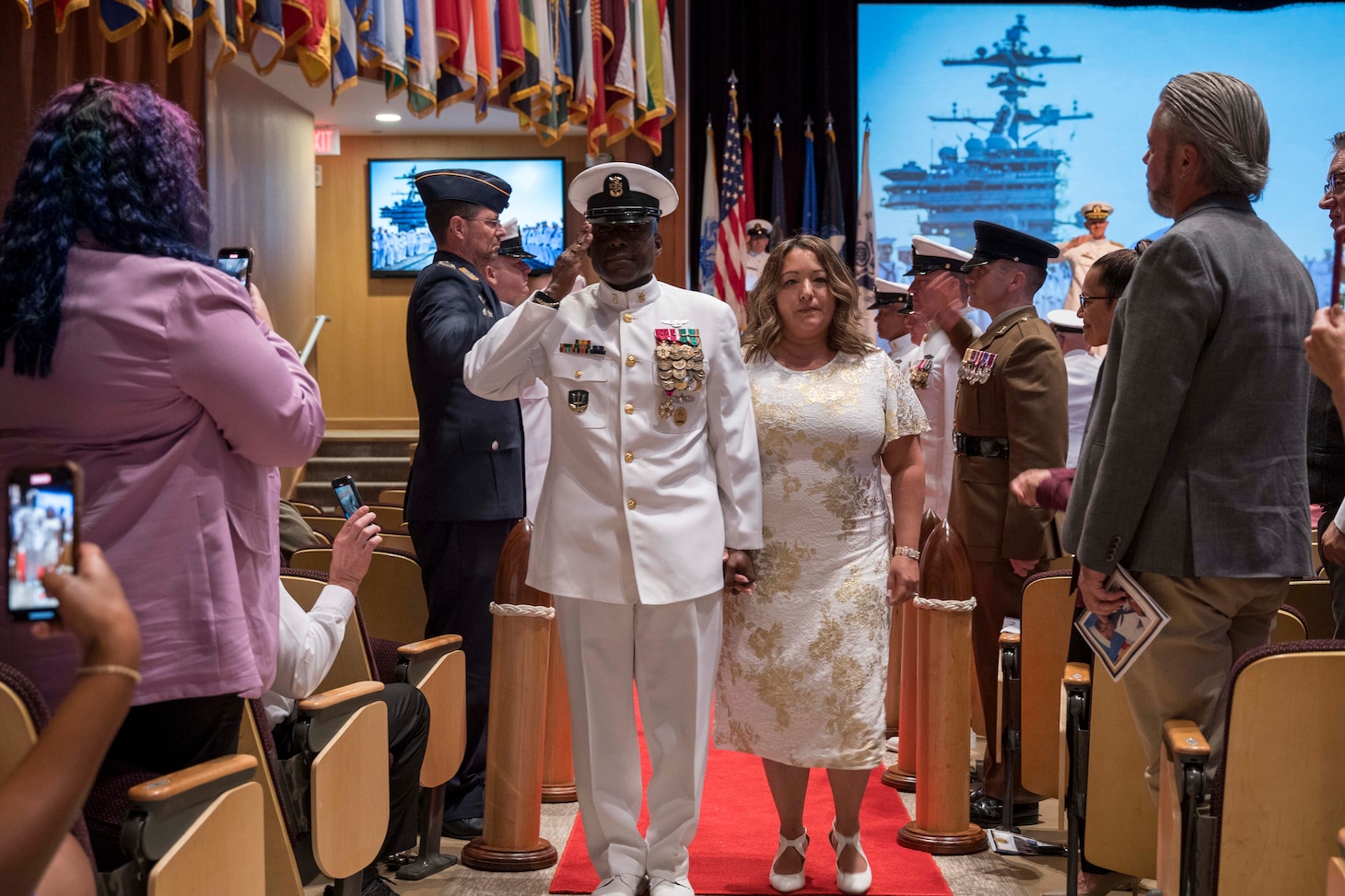 Fleet Command Master Chief Huben Phillips walks ashore with his spouse following his retirement ceremony, Aug. 11, 2023.