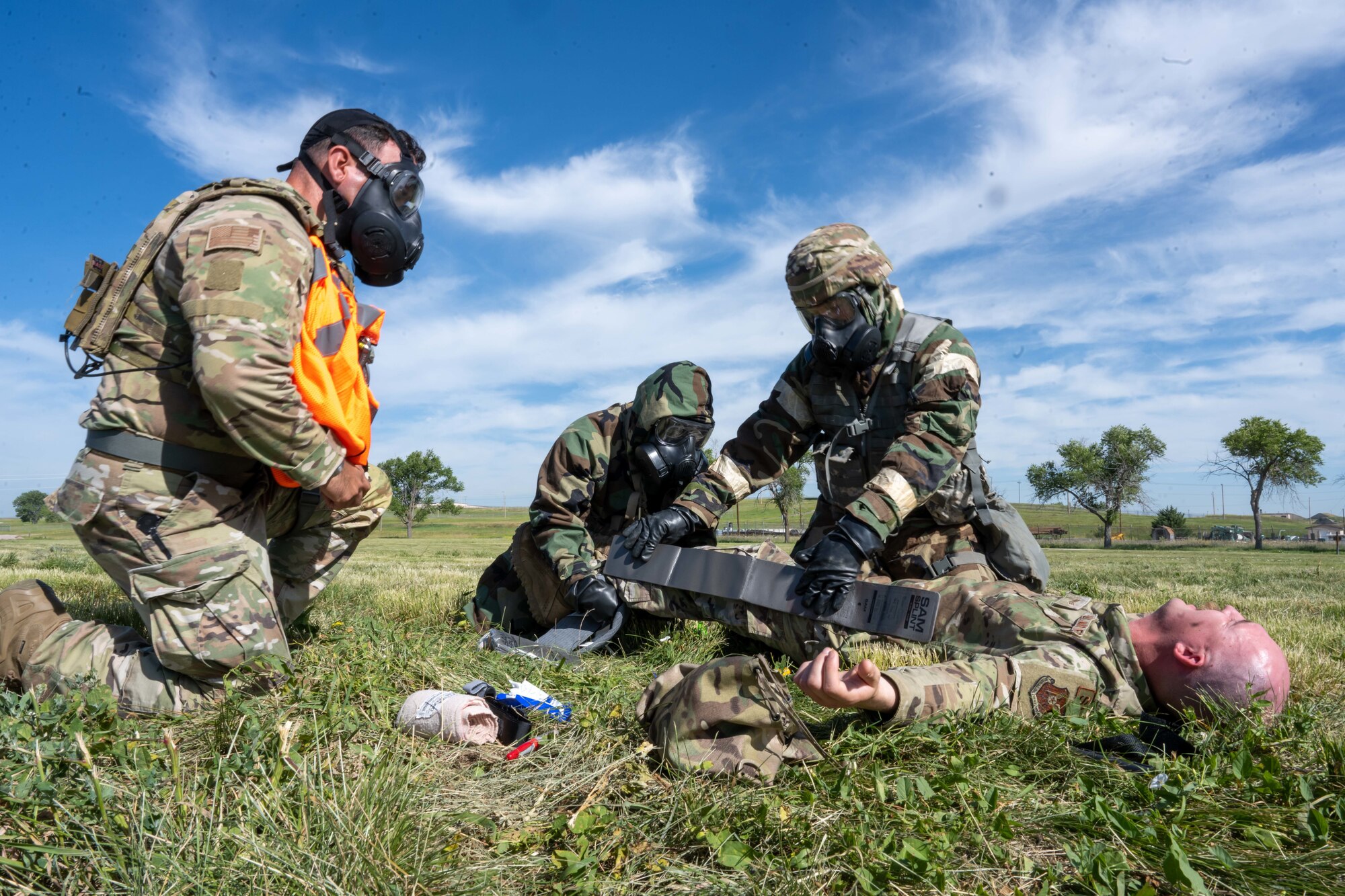 Airmen with the 28th Civil Engineering Squadron perform Tactical Combat Casualty Care (TCCC) on an airman simulating an injury during an exercise on Ellsworth Air Force Base, South Dakota, July 26, 2023. The exercise used real actors as casualties to add a sense of realism. (U.S. Air Force Photo by Specialist 3 Adam Olson)