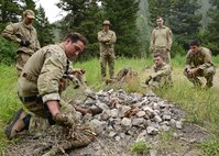 A group of 6 men surround a campfire.
