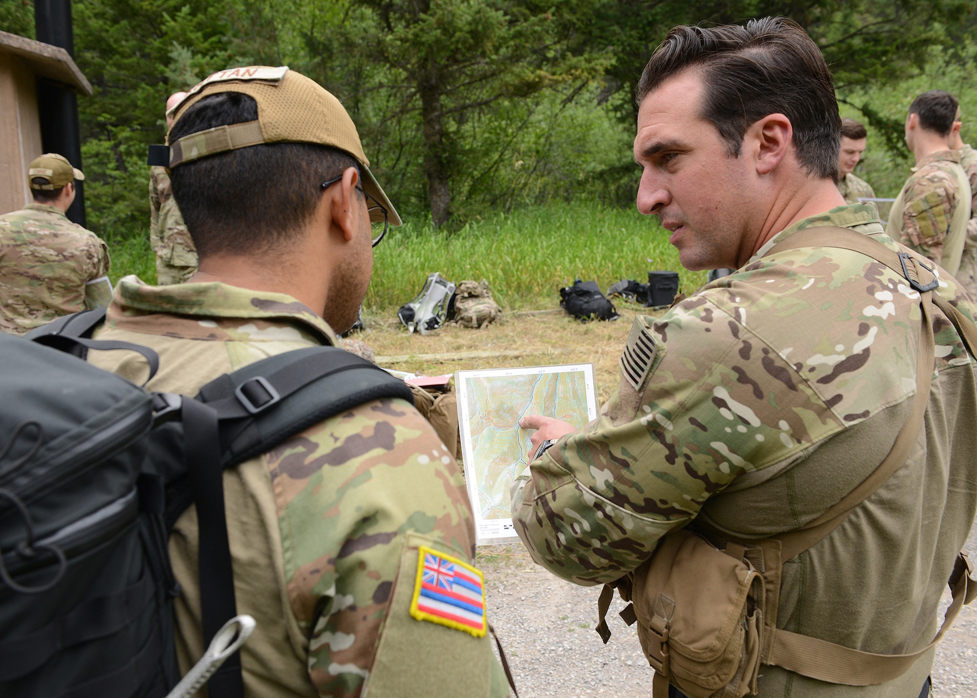 Two men in military uniform assess a paper map.