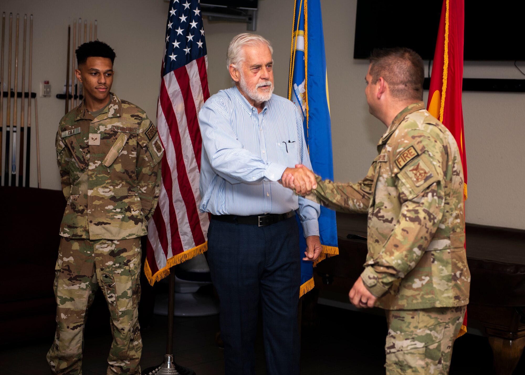 Jerry P. Weiers, Glendale, Arizona mayor, congratulates and coins Staff Sgt. Joseph Bove, 56th Civil Engineer Squadron firefighter, and Senior Airman Colby Cole, 56th CES firefighter, on Glendale, Arizona Aug. 9, 2023, at Luke Air Force Base, Arizona.