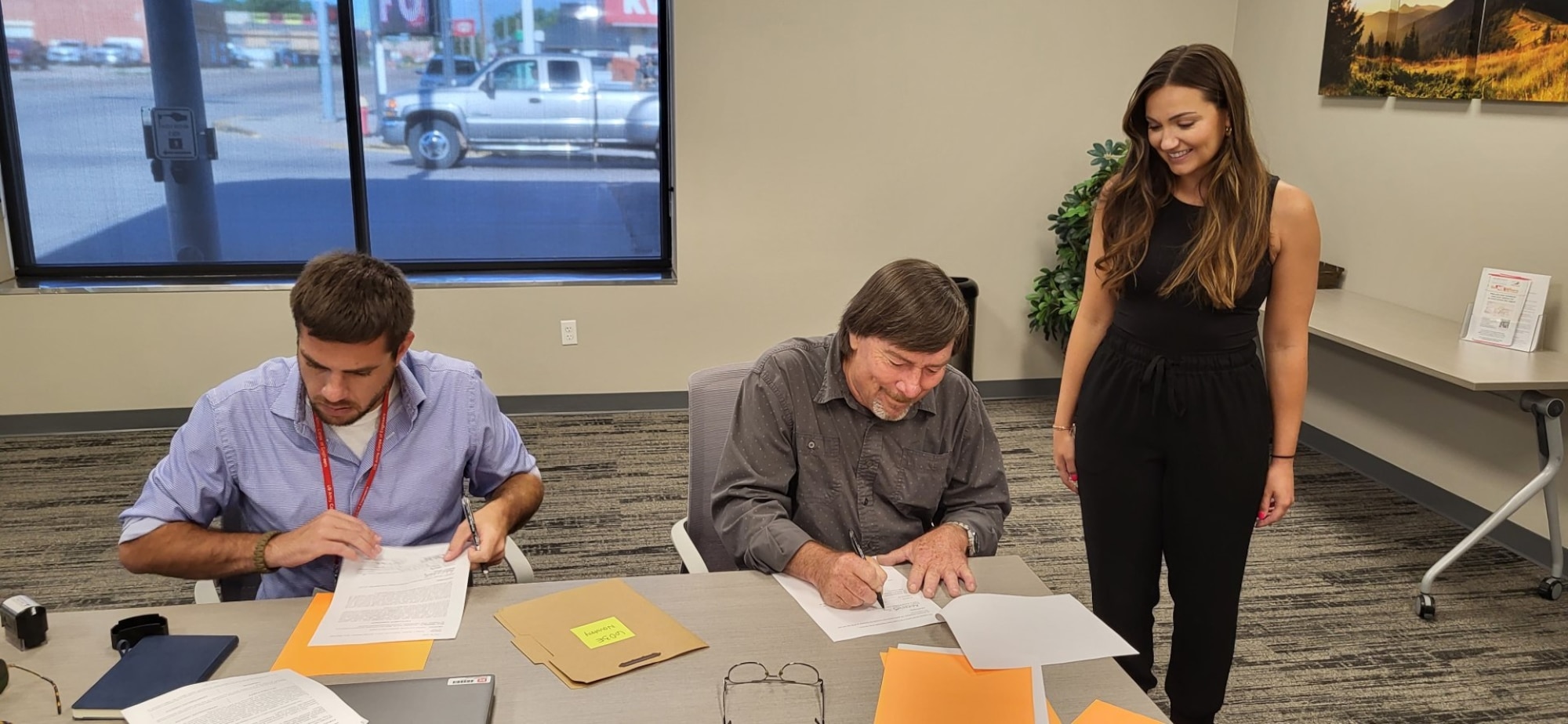 From left, Vince Crowdy, U.S. Army Corps of Engineers, Omaha District, senior realty specialist and notary; Richard Novotny, trustee of the Carol A. Novotny Residuary Trust; and Paige Staroscik, USACE Omaha District senior realty specialist, work on the paperwork for the closing of the first land acquisition for the new Sentinel Program, Aug. 1, 2023, in Cheyenne, Wyoming. AFGSC partnered with USACE and their Omaha District’s Sentinel real estate team who acted as the purchasing agents. (Courtesy Photo)