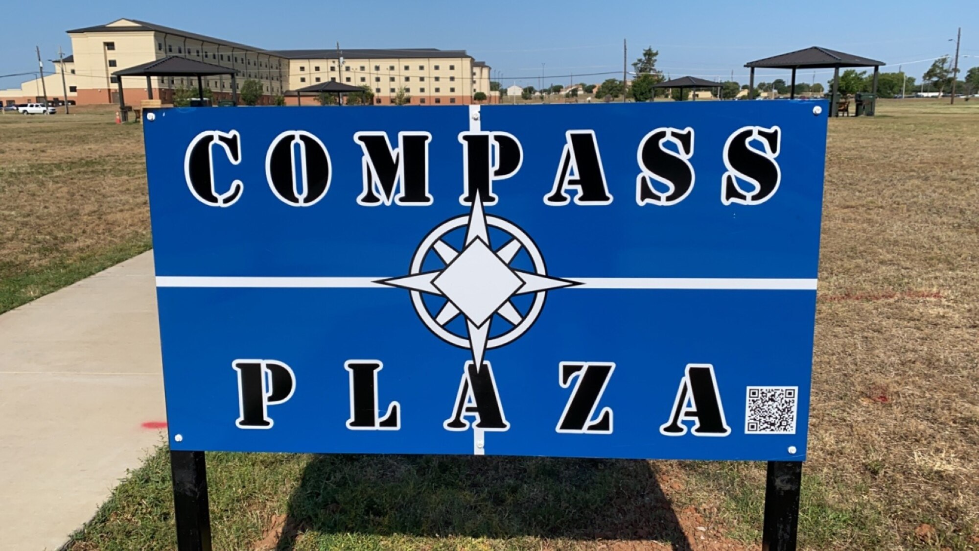 A blue sign that reads "Compass Plaza.
