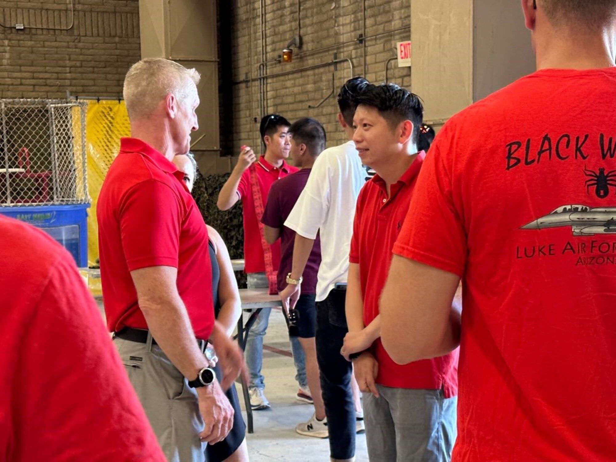 U.S. Air Force Brig. Gen. Jason M. Rueschhoff, 56th FW commander, speaks with Republic of Singaporean Air Force member at a National Day of Singapore event Aug. 8, 2023, at Luke Air Force Base, Arizona.