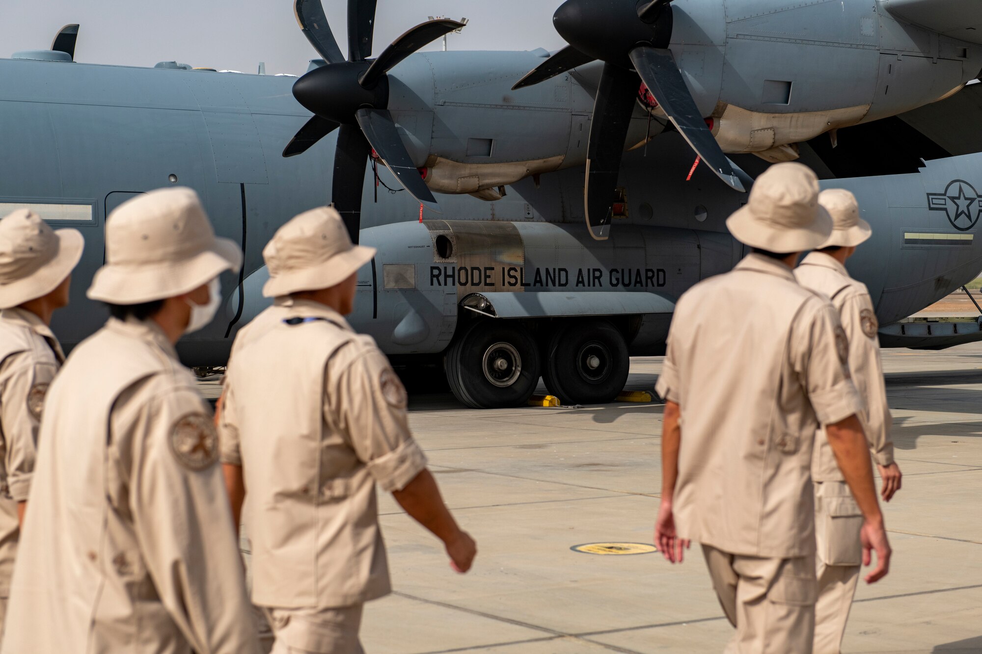 Photo of service members walking past a cargo plane