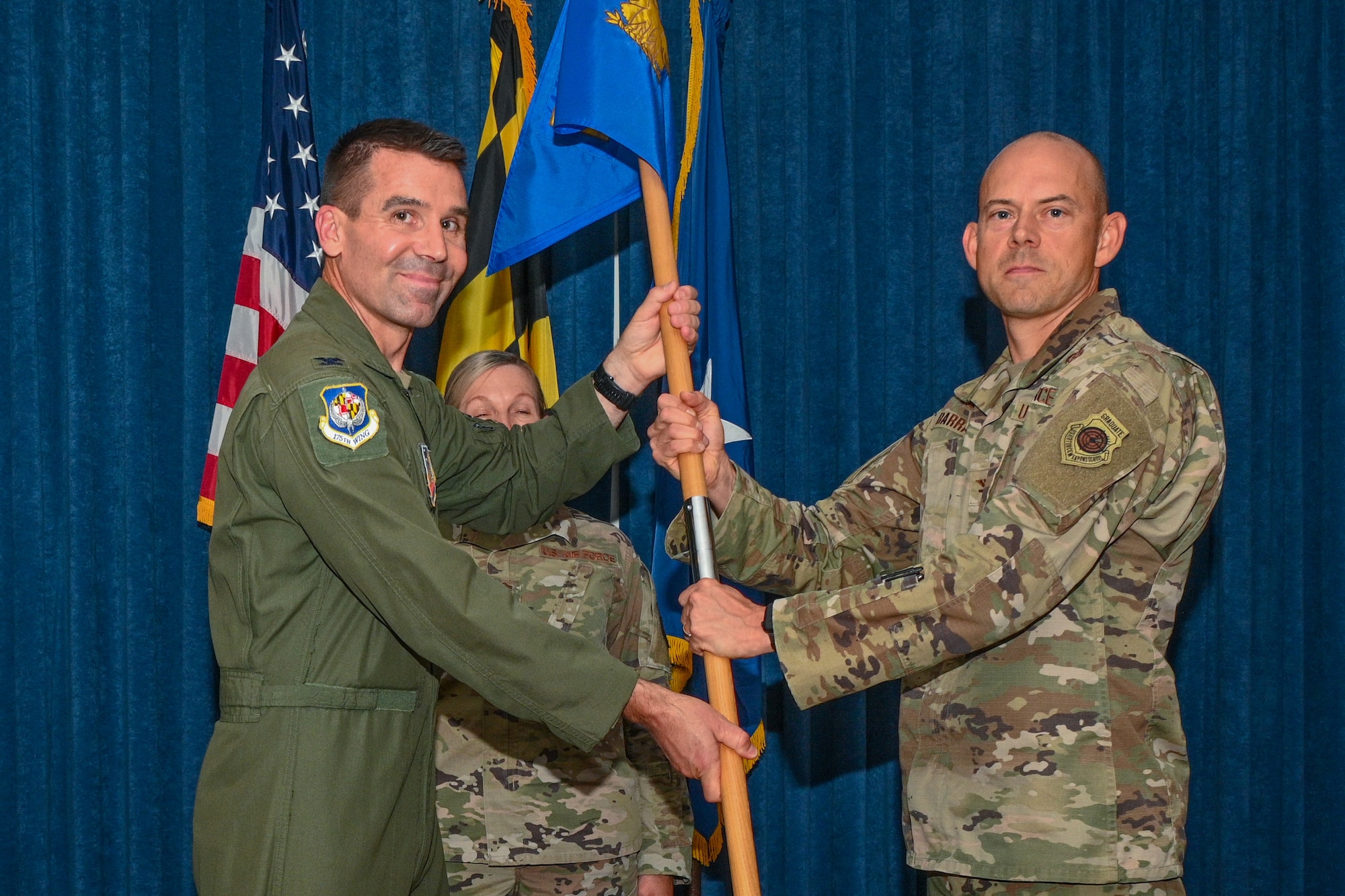 U.S. Air Force Col. Richard Hunt, left, 175th Wing commander, presents the guidon to Col. Jason Barrass, right, 175th Cyberspace Operations Group incoming commander, during the 175th COG change of command ceremony, August 12, 2023, at Martin State Air National Guard Base, Maryland.