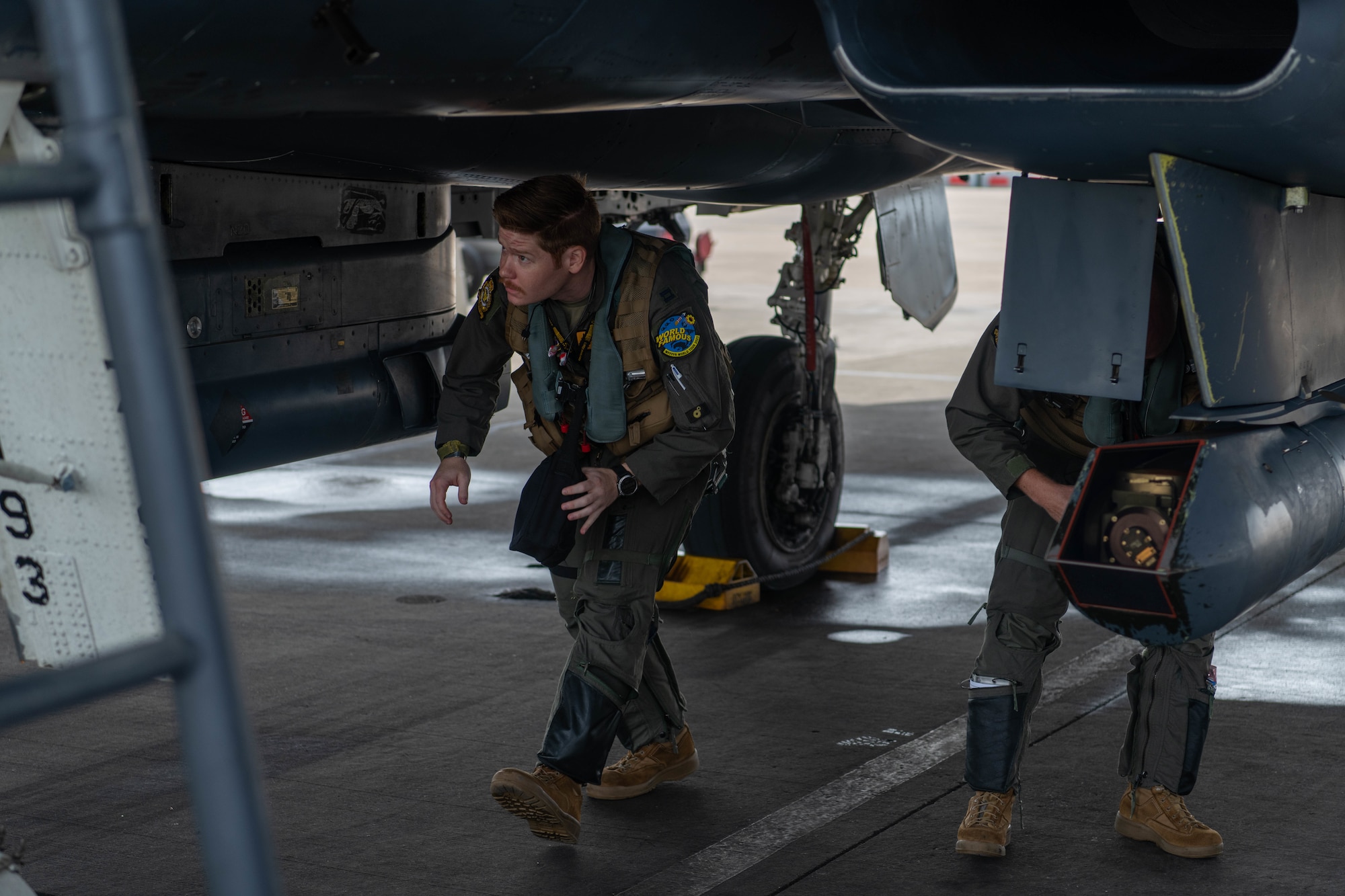 Two pilots conduct inspections on an F-15E Strike Eagle.