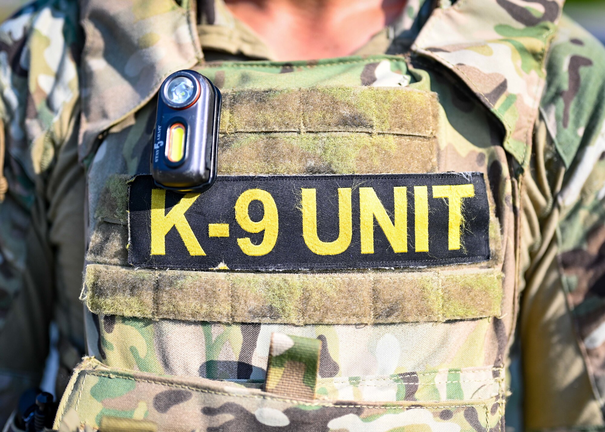 A soldiers body armor dons a patch reading "K-9 unit."