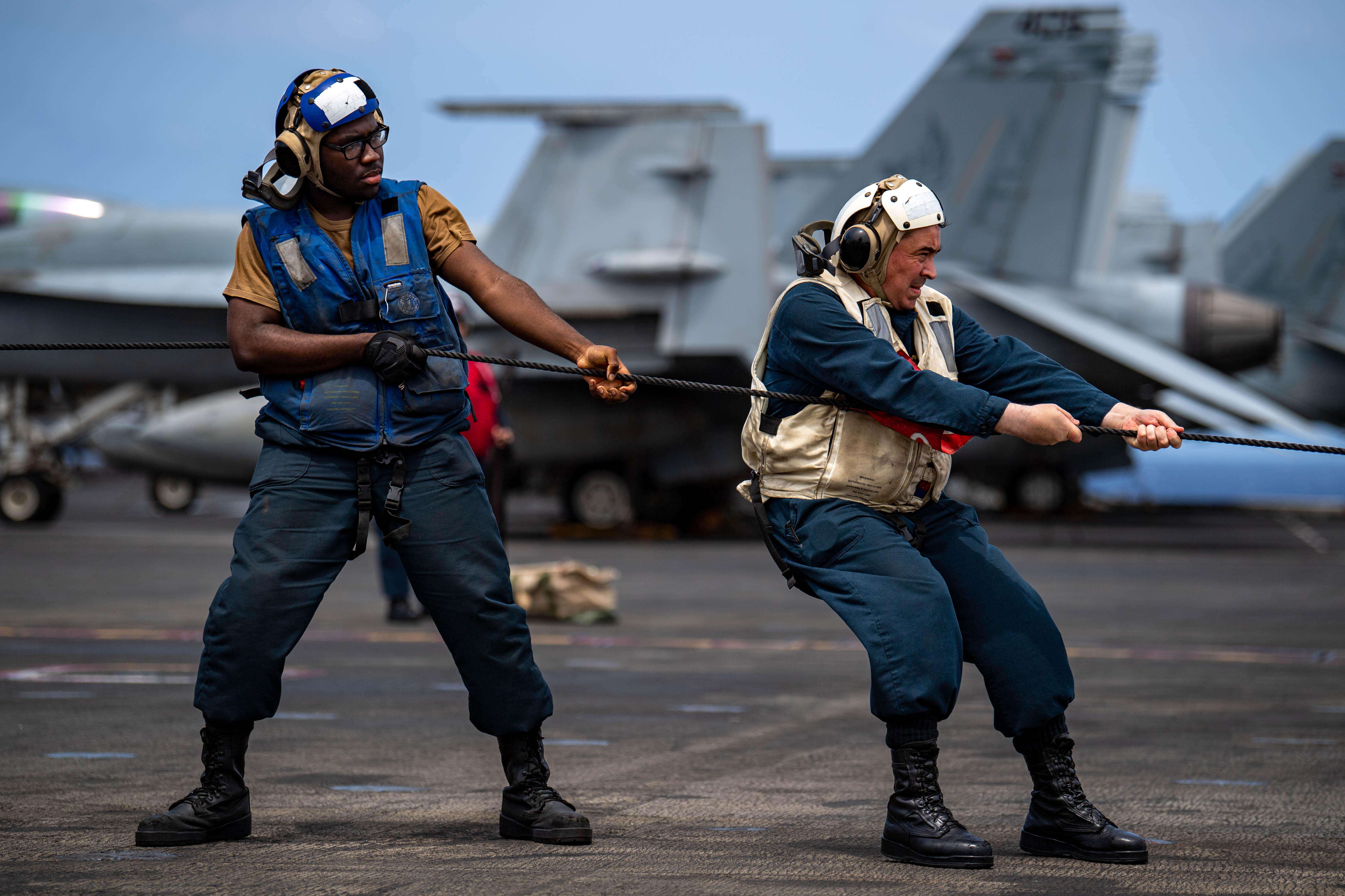 Senior Chief Boatswain’s Mate Pat Drumm, from Upper Darby, Pennsylvania, and Seaman Davon Vileenor, from Lauderhill, Florida, heaves the phone and distance line on the flight deck as Military Sealift Command dry cargo and ammunition ship, USNS Carl Brashear (T-AKE 7), comes alongside for a replenishment-at-sea with the U.S. Navy’s only forward-deployed aircraft carrier, USS Ronald Reagan (CVN 76), in the Philippine Sea, August 9, 2023.