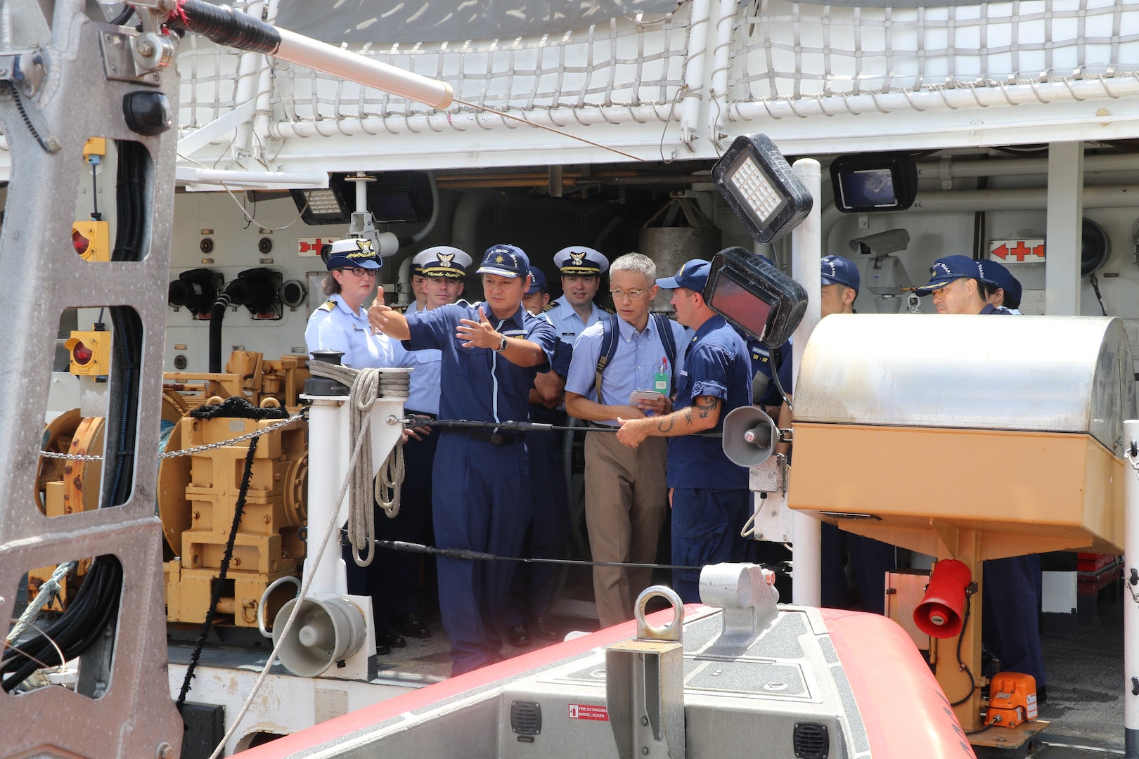 Petty Officer 2nd Class Noah Farris, a U.S. Coast Guard Cutter Munro (WMSL 755) crew member, discusses the cutter’s small boat stern launch capabilities with members from the Japan Coast Guard aboard the Munro during the cutter’s port call to Yokosuka, Japan, Aug. 8, 2023. Yokosuka was Munro’s first international port call during their months-long deployment to the Indo-Pacific region. (U.S. Coast Guard photo)