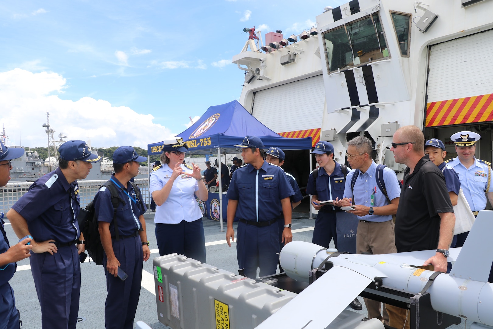 Capt. Rula Deisher, U.S. Coast Guard Cutter Munro’s (WMSL 755) commanding officer, discusses the cutter’s unmanned aerial system capabilities with members from the Japan Coast Guard aboard the Munro during the cutter’s port call to Yokosuka, Japan, Aug. 8, 2023. Yokosuka was Munro’s first international port call during their months-long deployment to the Indo-Pacific region. (U.S. Coast Guard photo)