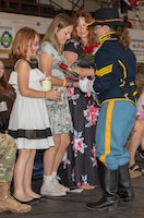 Milley and Maddie Mullinax, the daughters of U.S. Army Command Sgt. Maj. Christopher L. Mullinax, the outgoing command sergeant major 1st Infantry Division and Fort Riley, receive red roses from U.S. Army Sgt. Alexis M. Finley, a sergeant assigned to the 1st Inf. Div. Commanding General's Mounted Color Guard, during a Victory with Honors and relinquishment of responsibility ceremony at King Field House on Fort Riley, Kansas, Aug. 9, 2023. The 1st Inf. Div. recognized Milley and Maddie Mullinax for their support to the Big Red One. (U.S. Army photo by Spc. Dawson Smith)