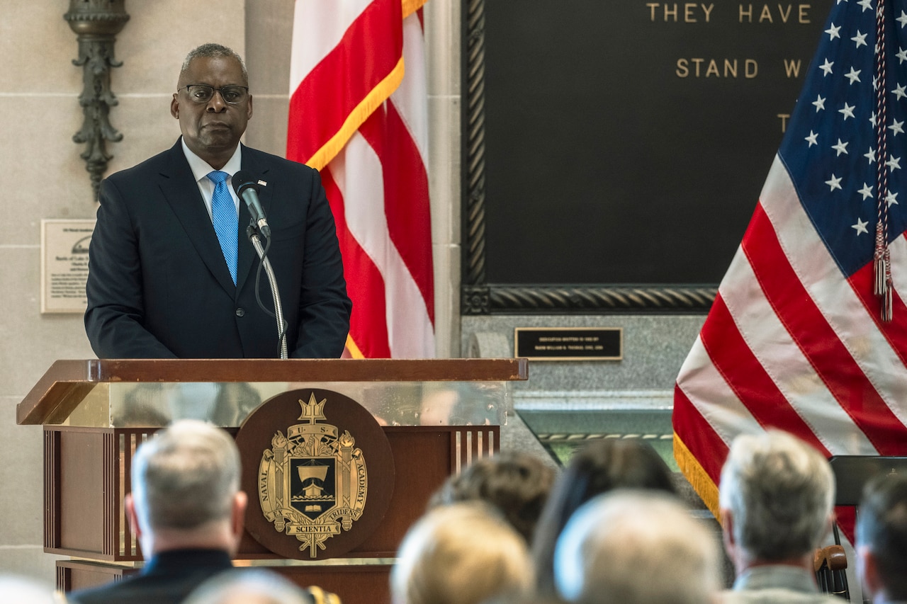 Secretary of Defense Lloyd J. Austin III speaks from a stage.