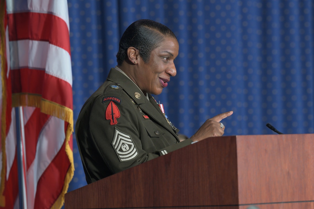 An Army Command Sergeant Major speaks at a podium during a ceremony.