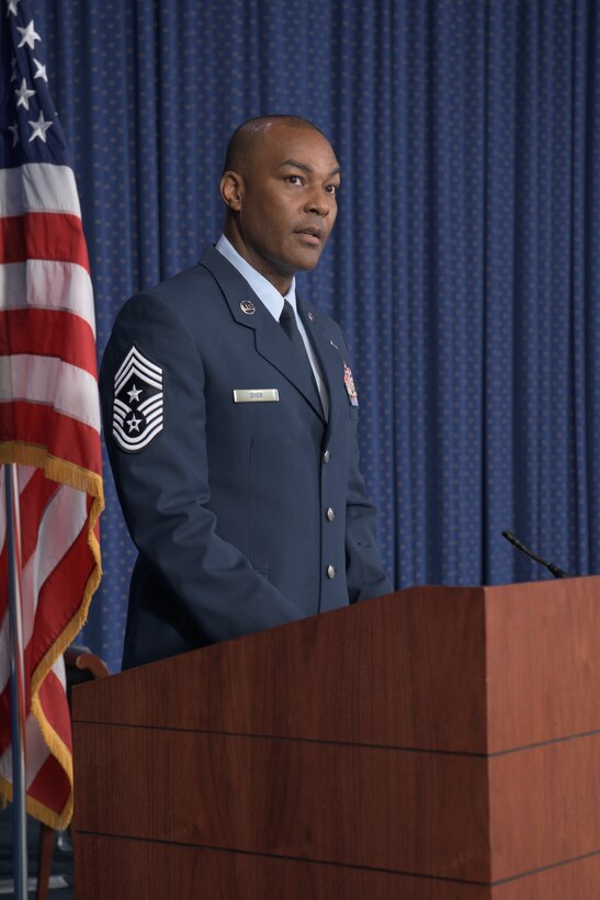 An Air Force officer speaks at a podium during a ceremony.