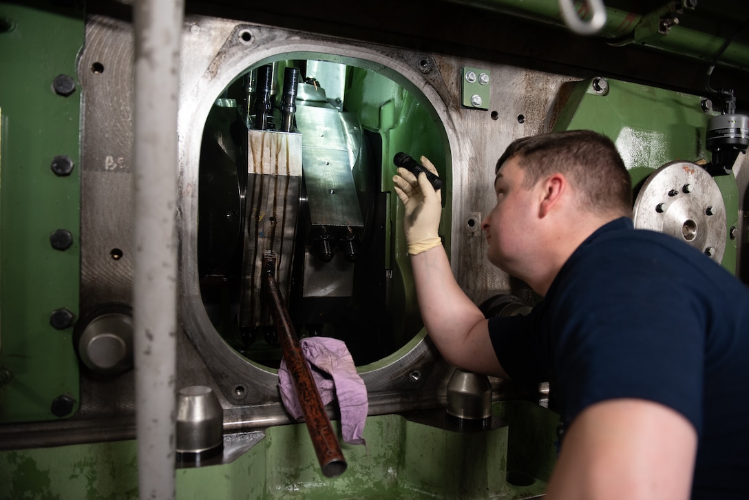 A Coast Guard Cutter Healy (WAGB 20) crew member conducts repairs following a jacket water leak on a main diesel engine by disassembling the connecting rod from the crank shaft, removing the cylinder liner, and locating the source of the leak aboard the cutter in the Beaufort Sea, Aug. 10, 2023. Having all engines available for use is critical to the Healy’s ability to produce adequate power to break multi-year ice while simultaneously operating powerful deck and science equipment. (Coast Guard photo by Petty Officer 3rd Class Briana Carter)
