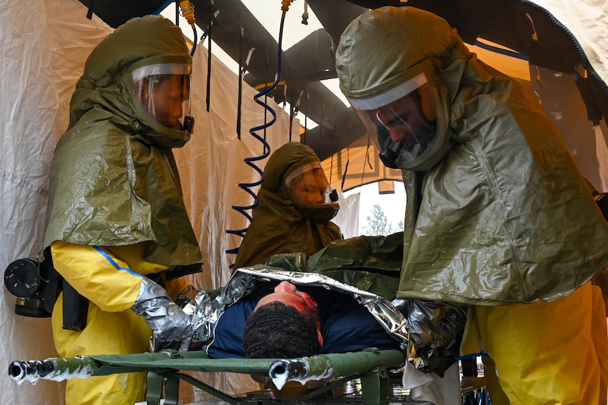 5th Medical Group Patient Decontamination Team first responders decontaminate a patient during Exercise Ready Eagle at Minot Air Force Base, North Dakota, Aug. 10, 2023. The decontamination teams constructed an impromptu facility to combat the aftermath of a simulated chemical disaster. (U.S. Air Force photo by Senior Airman Zachary Wright)