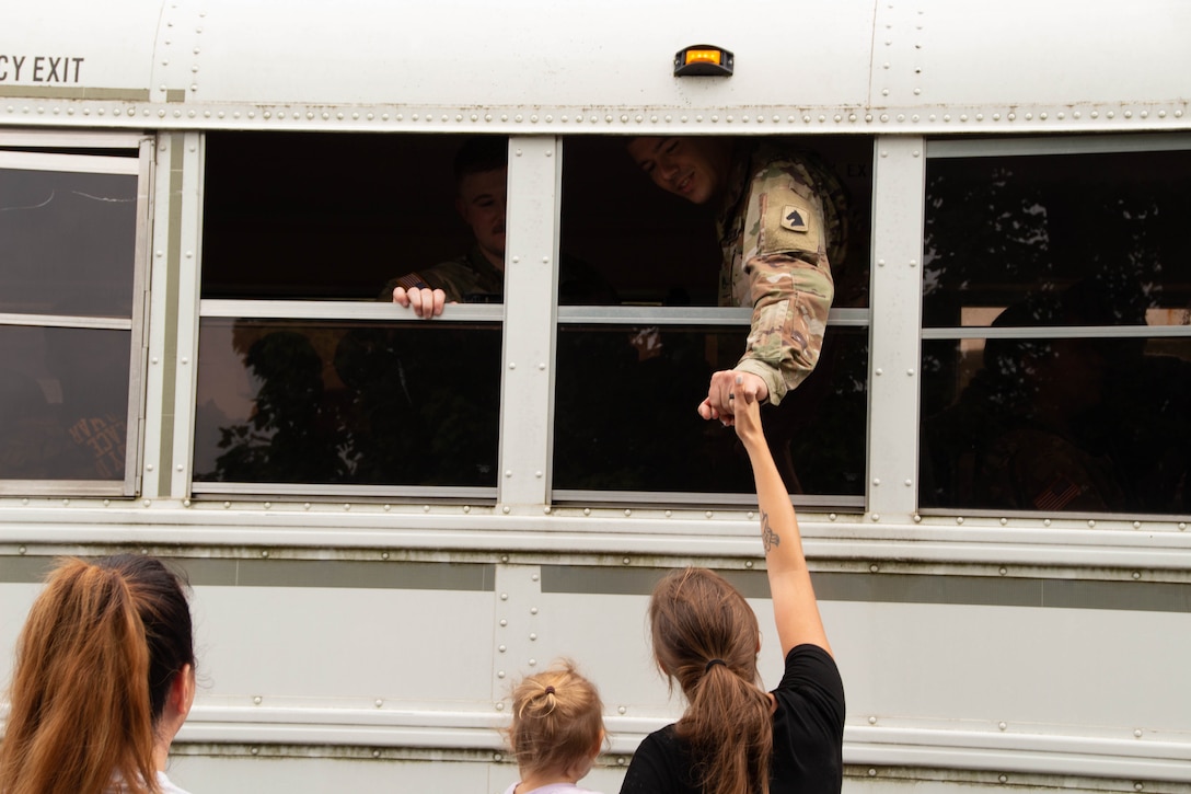 Staff Sgt. Christopher Doker has one last goodbye from the bus outside the Lexington Armory in Lexington, Kentucky on August 14, 2023. HHB, 138th Field Artillery Brigade is deploying to Southwest Asia in support of Operation Spartan Shield. (U.S. Army National Guard photo by Milt Spalding)