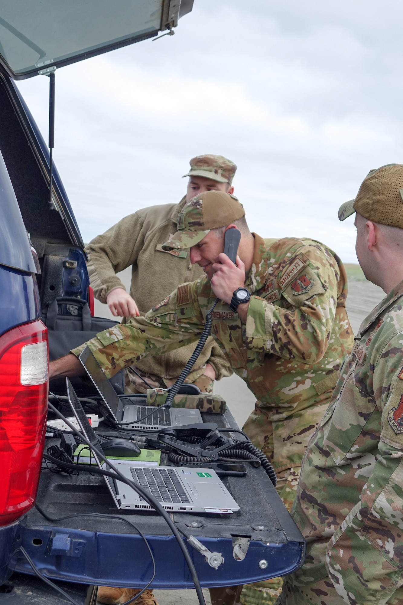 Airmen talk on radio to fighter aircraft