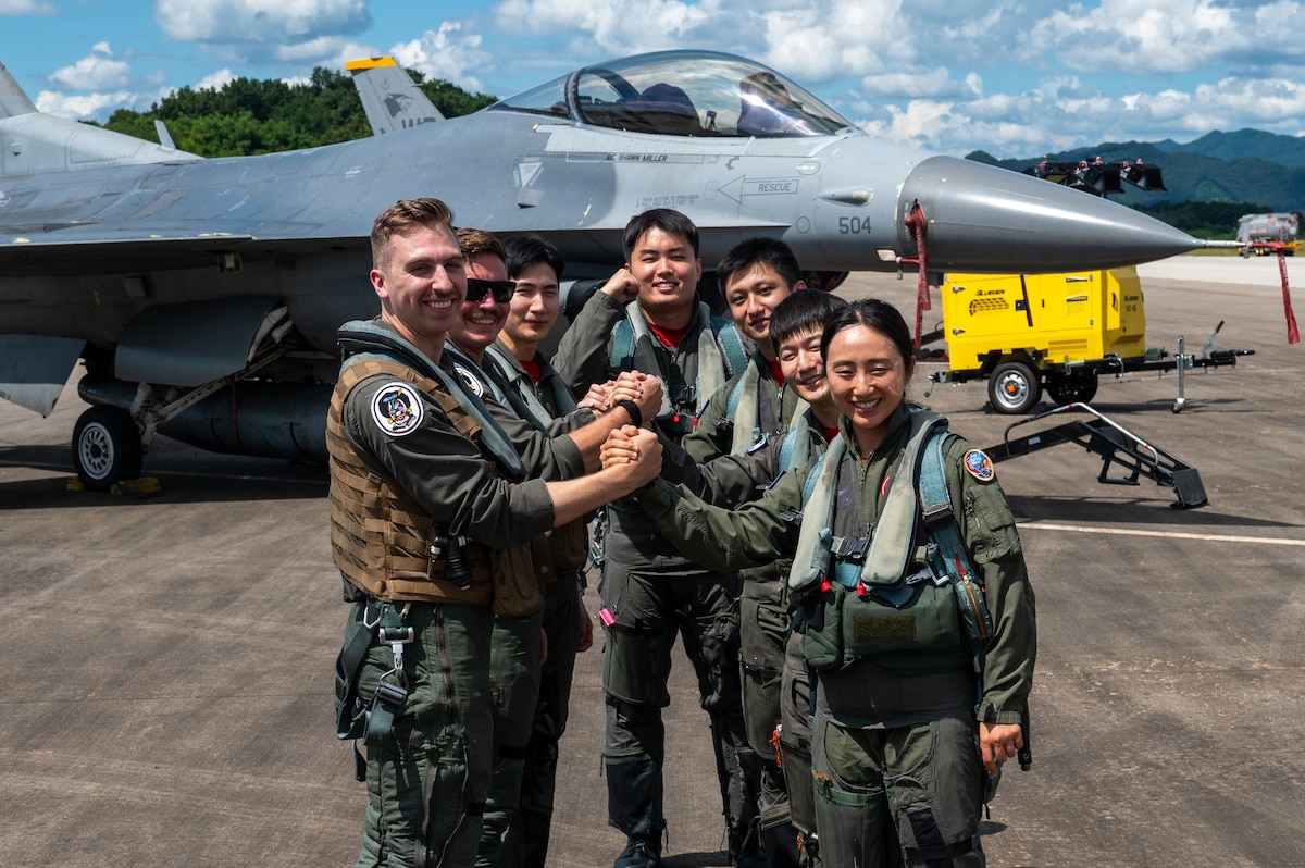 Pilots from the U.S. Air Force and the Republic of Korea Air Force clasp hands after a successful training flight during a U.S.-ROK Buddy Squadron event.