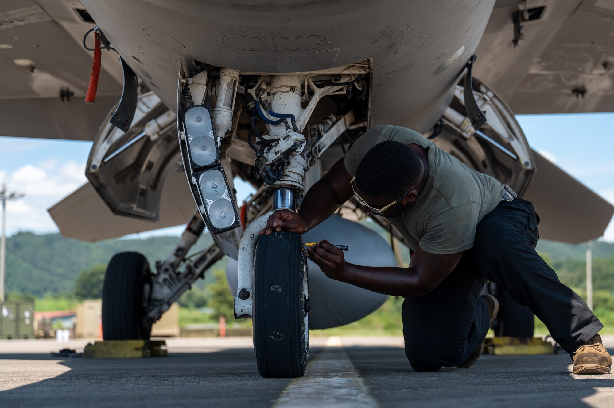 Staff Sgt. Charles Clark marks the tire of a U.S. Air Force F-16 Fighting Falcon during a U.S.-Republic of Korea Buddy Squadron event.
