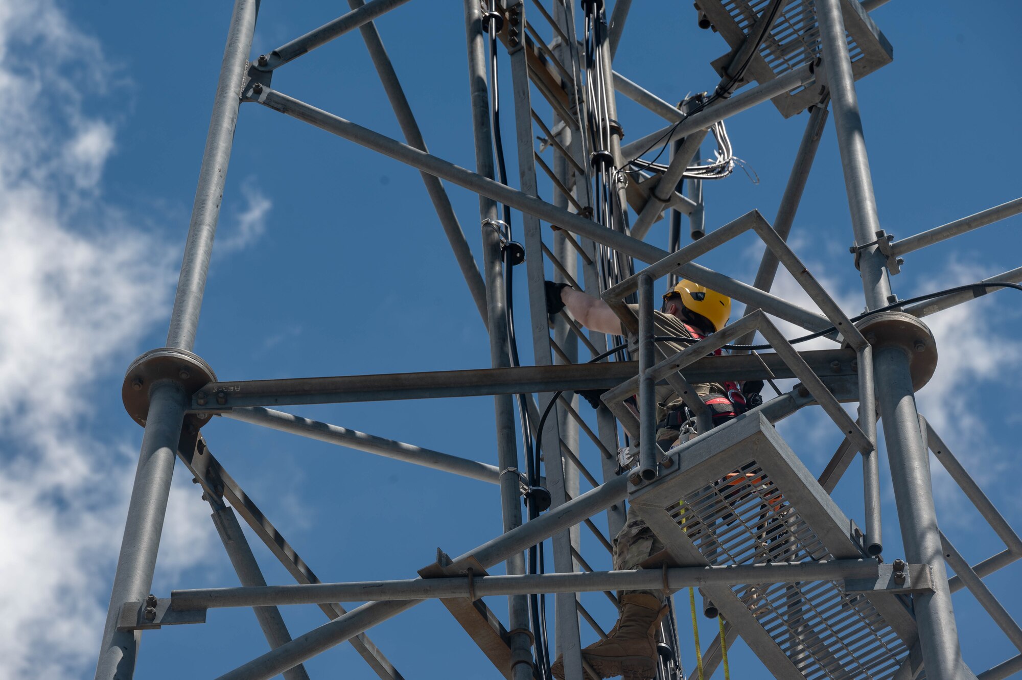 U.S. Air Force Airman 1st Class Gregory Hubof, 607th Air Control Squadron radio frequency transmission systems technician, ascends a radio tower Aug. 1, 2023, at Mount Lemmon in Tucson, Arizona.