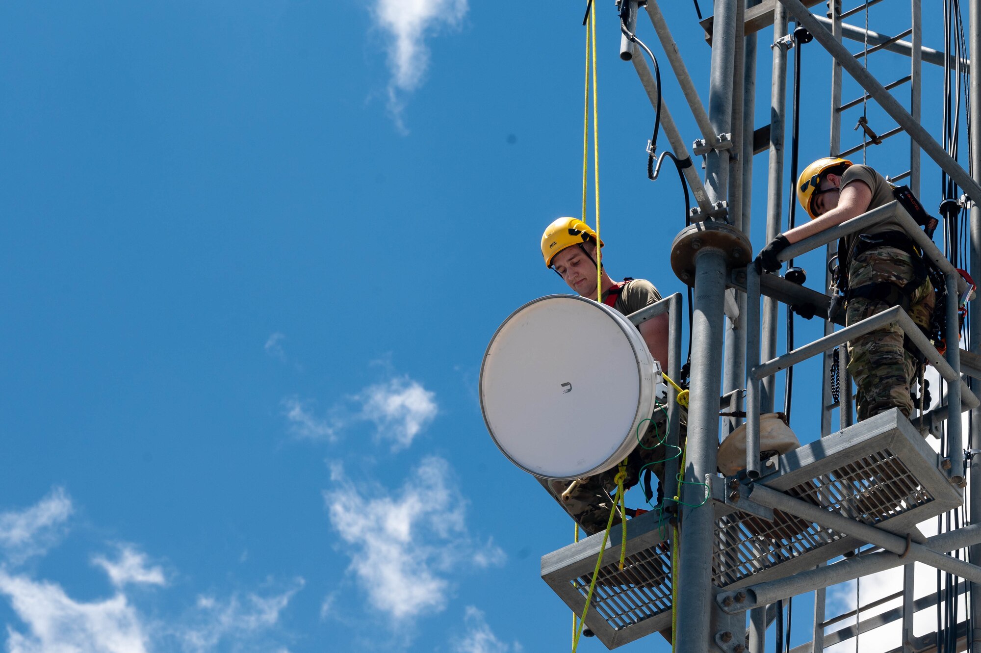 U.S. Air Force Airman 1st Class Gregory Hubof (left) and U.S. Air Force Airman 1st Class Jonathan Nabicht (right), 607th Air Control Squadron radio frequency transmission systems technicians, mount a radio system Aug. 1, 2023, at Mount Lemmon in Tucson, Arizona.