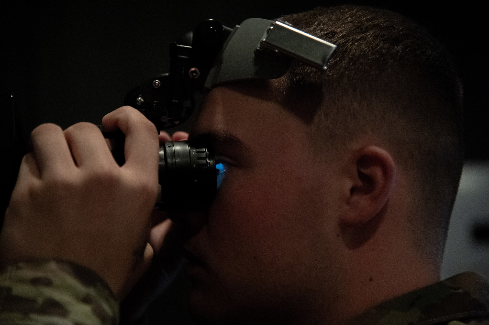 An Airman looks through night vision goggles.