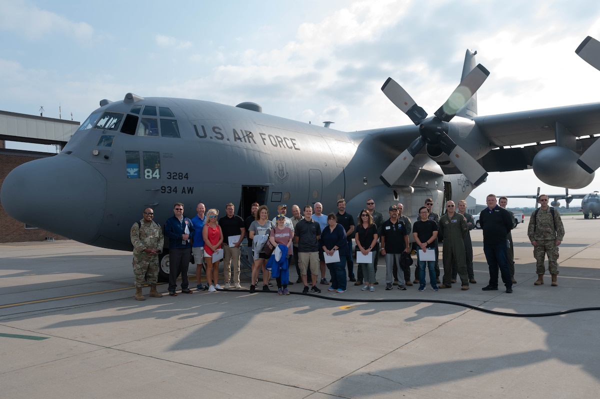 Employers and 934th Airlift Wing Airmen pose for a group photo with a C-130H Hercules aircraft during Employers Day at Minneapolis-St. Paul Air Reserve Station, Minn., Aug. 5, 2023. Employers Day is an opportunity for 934 AW Airmen to invite their civilian employers to a base event to thank them for their support. (U.S. Air Force photo by Senior Airman Victoriya Tarakanova)