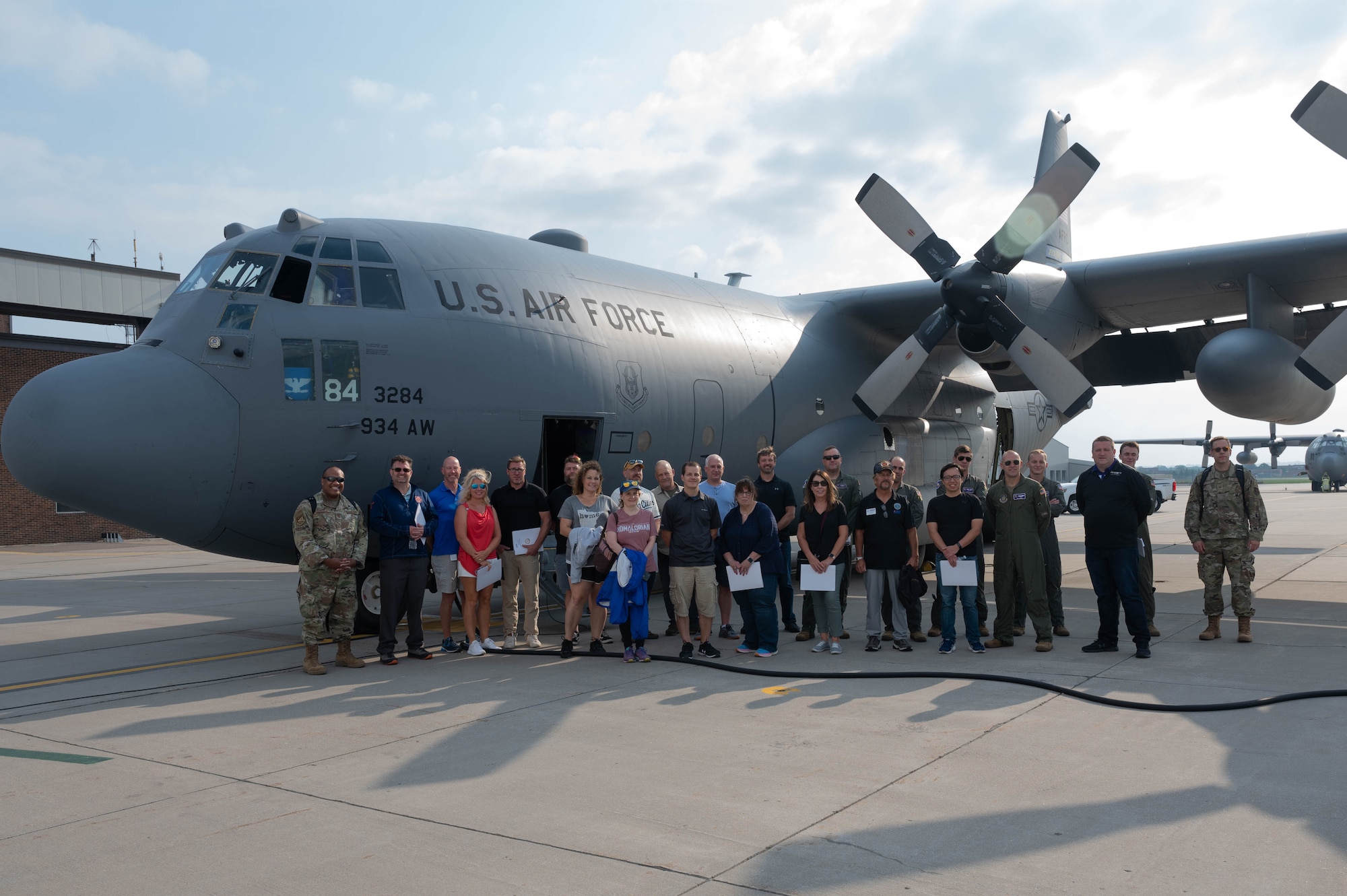 Employers and 934th Airlift Wing Airmen pose for a group photo with a C-130H Hercules aircraft during Employers Day at Minneapolis-St. Paul Air Reserve Station, Minn., Aug. 5, 2023. Employers Day is an opportunity for 934 AW Airmen to invite their civilian employers to a base event to thank them for their support. (U.S. Air Force photo by Senior Airman Victoriya Tarakanova)