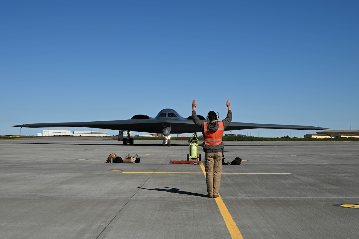 A crew chief assigned to the 393rd Expeditionary Bomb Squadron, ushers a  B-2 Spirit in Keflavik, Iceland to participate in a Bomber Task Force Europe operation with NATO allies, Aug. 13, 2023.