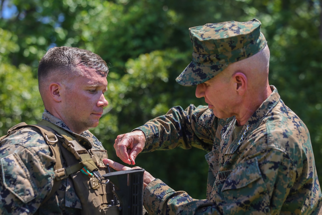 The 36th Assistant Commandant of the Marine Corps, Gen. Eric M. Smith, pins sergeant ranks onto Sgt. Peyton Nott, a Jefferson City, Tennessee native, and motor vehicle operator with 1st Battalion, 10th Marine Regiment 2d Marine Division, during a Marine Corps Combat Readiness Evaluation on Camp Lejeune, North Carolina, July 24, 2023. Nott was awarded in recognition of his ability to take on the responsibilities and duties of a higher grade in an effective manner while working with Romeo Battery, 1st Battalion, 10th Marine Regiment, 2d Marine Division. General Smith visited Marines with 1st Battalion, 10th Marine Regiment, 2d Marine Division as part of a command tour. (U.S. Marine Corps photos by Lance Cpl. Ryan Ramsammy)