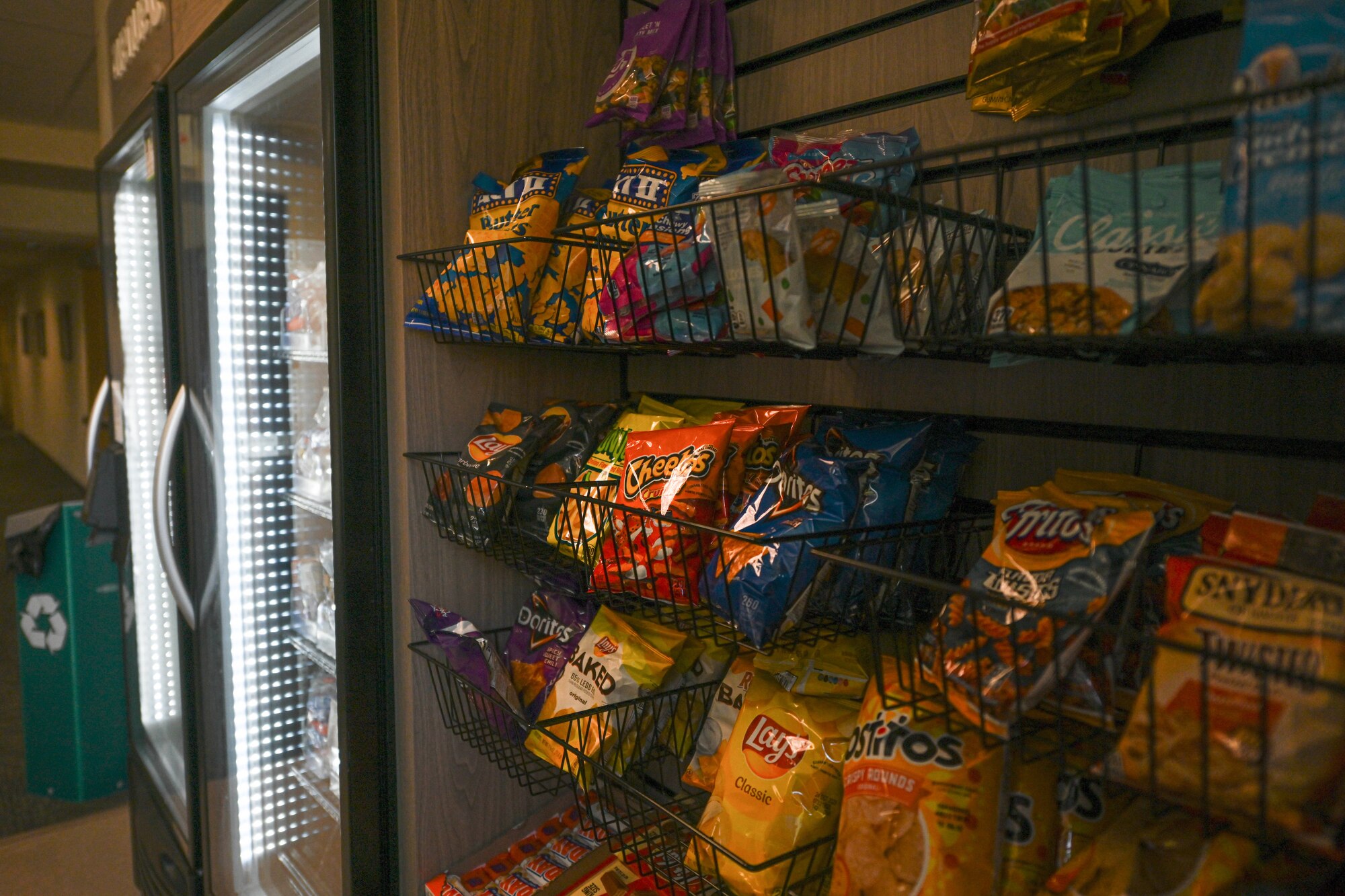 Bags of snacks are lined up on shelves.