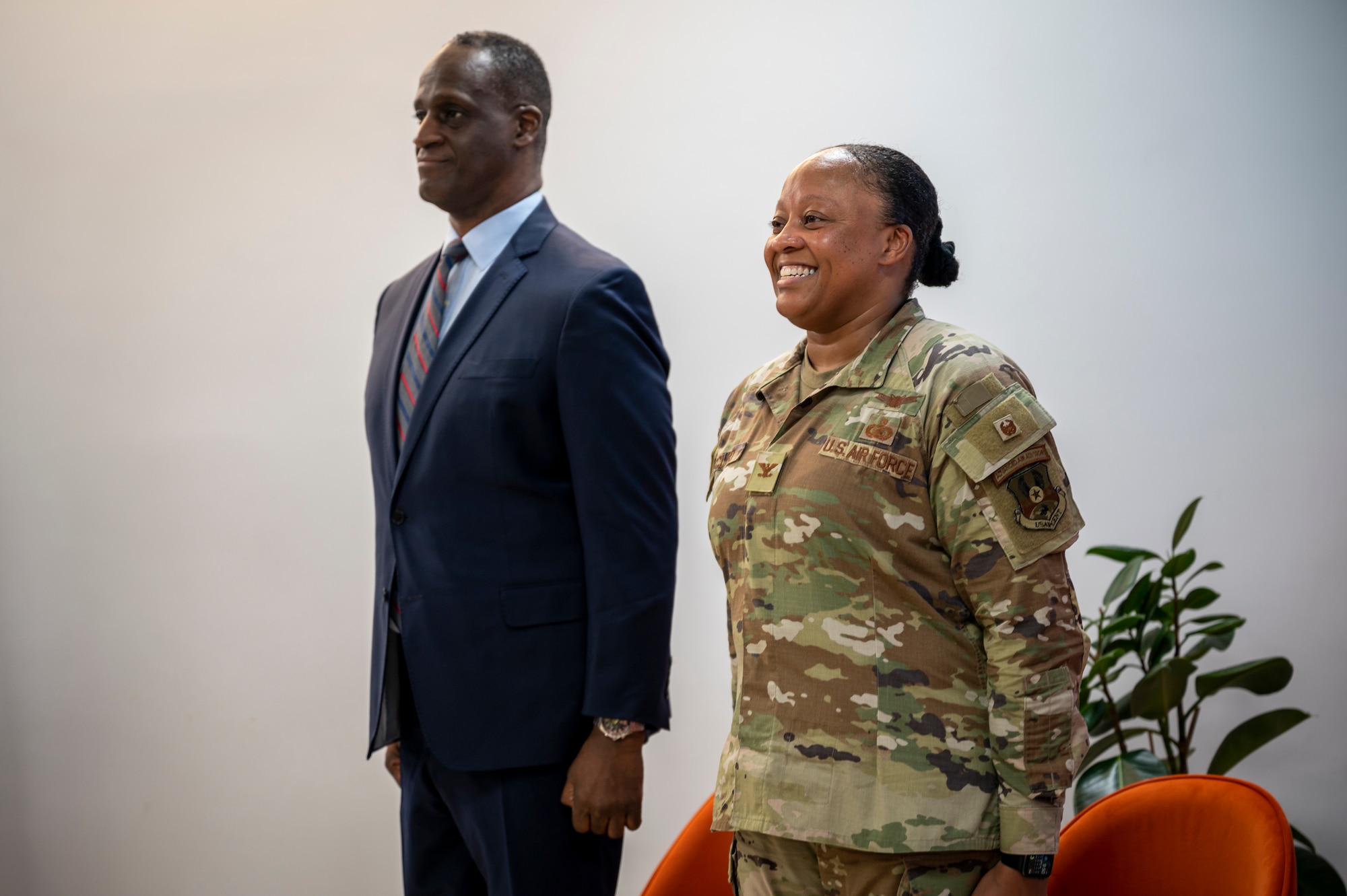 A military member in uniform stands next to the U.S. Ambassador to Qatar at attention.