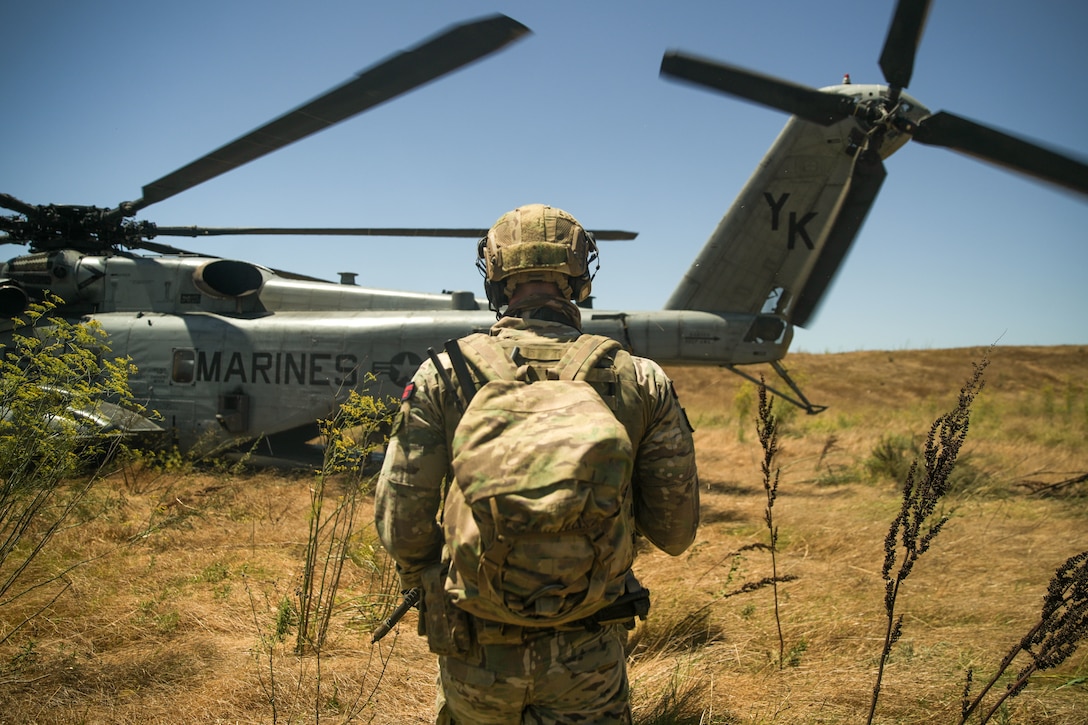 xA British Royal Marines Commando assigned to 40 Commando, currently attached to the 15th Marine Expeditionary Unit, prepares to board a CH-53E Super Stallion attached to Marine Medium Tiltrotor Squadron (VMM) 165 (Reinforced), 15th MEU, for a helicopter raid during an amphibious raid course at Marine Corps Base Camp Pendleton, California, Aug. 2, 2023. The raid course, conducted by Expeditionary Operations Training Group, I Marine Expeditionary Force, teaches and evaluates MEU forces’ capabilities to complete effective raids to seize an area to deny enemy actions and potentially provide information for future operations. (U.S. Marine Corps photo by Sgt. Smith)