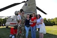 U.S. Army Staff Sgt. Brandon Krott, a crew chief with Delta Company, 2-104th General Support Aviation Battalion, 28th Expeditionary Combat Aviation Brigade poses for a photo in front of a CH-47 Chinook helicopter with his family during National Night Out in his hometown of Muhlenberg Township, Pennsylvania, August 1, 2023. (U.S. Army National Guard photo by 1st Lt. Samantha Gabriel)
