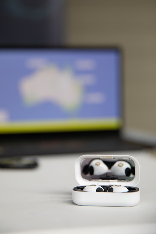 A case holds wearables technology in the foreground, in the background a computer screen shows the data visualization for the wearables equipment outputs on a map of the Australian continent.