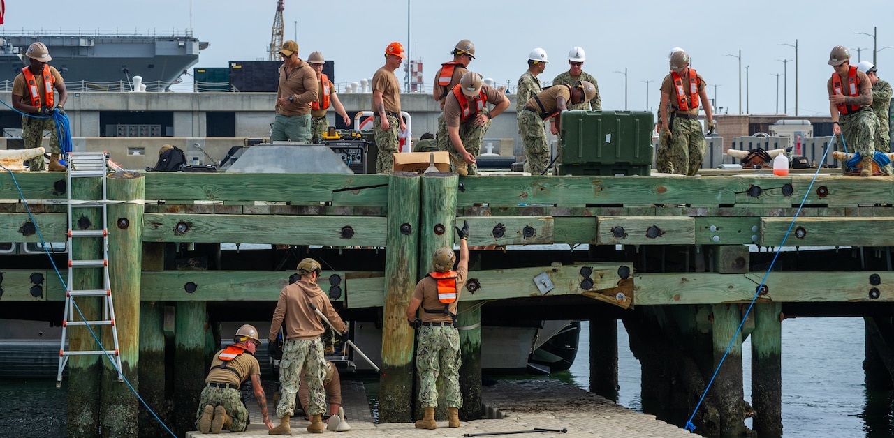 Sailors work on a bridge.