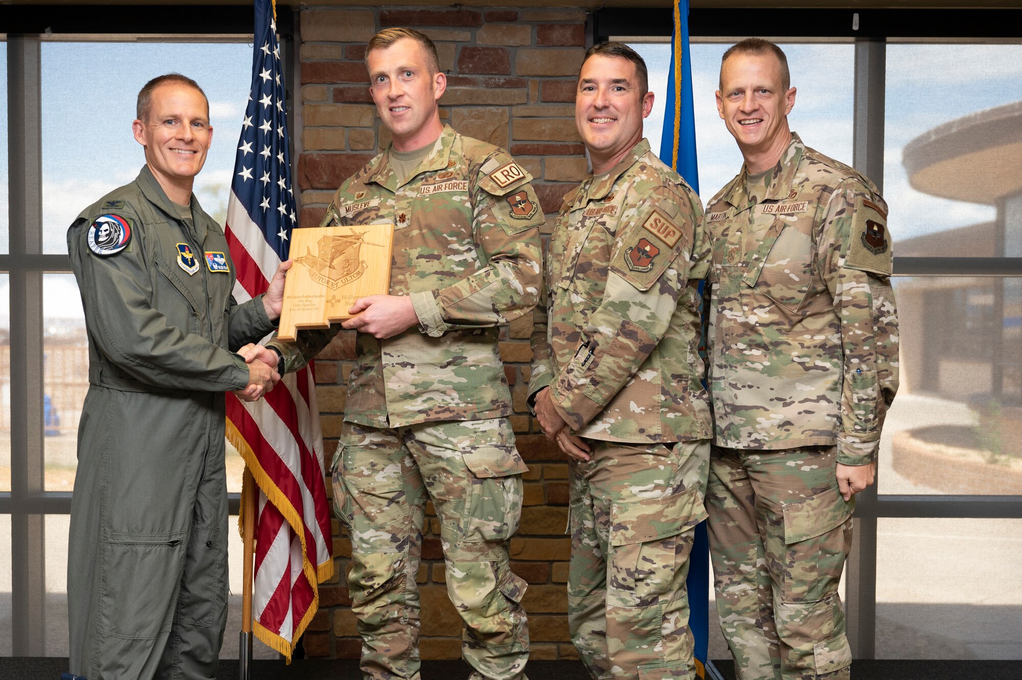 U.S. Air Force Maj. Daniel Musleve, left, and U.S. Air Force Chief Master Sgt. Scott Fitzpatrick, from the Logistics Readiness Squadron, accepts the 49th Wing’s Large Unit of the Quarter Award, during the 49th Wing’s 2nd Quarter Award ceremony at Holloman Air Force Base, New Mexico, Aug. 11, 2023. Quarterly award winners were selected based on their technical expertise, demonstration of leadership and job performance. (U.S. Air Force photo by Airman 1st Class Michelle Ferrari)
