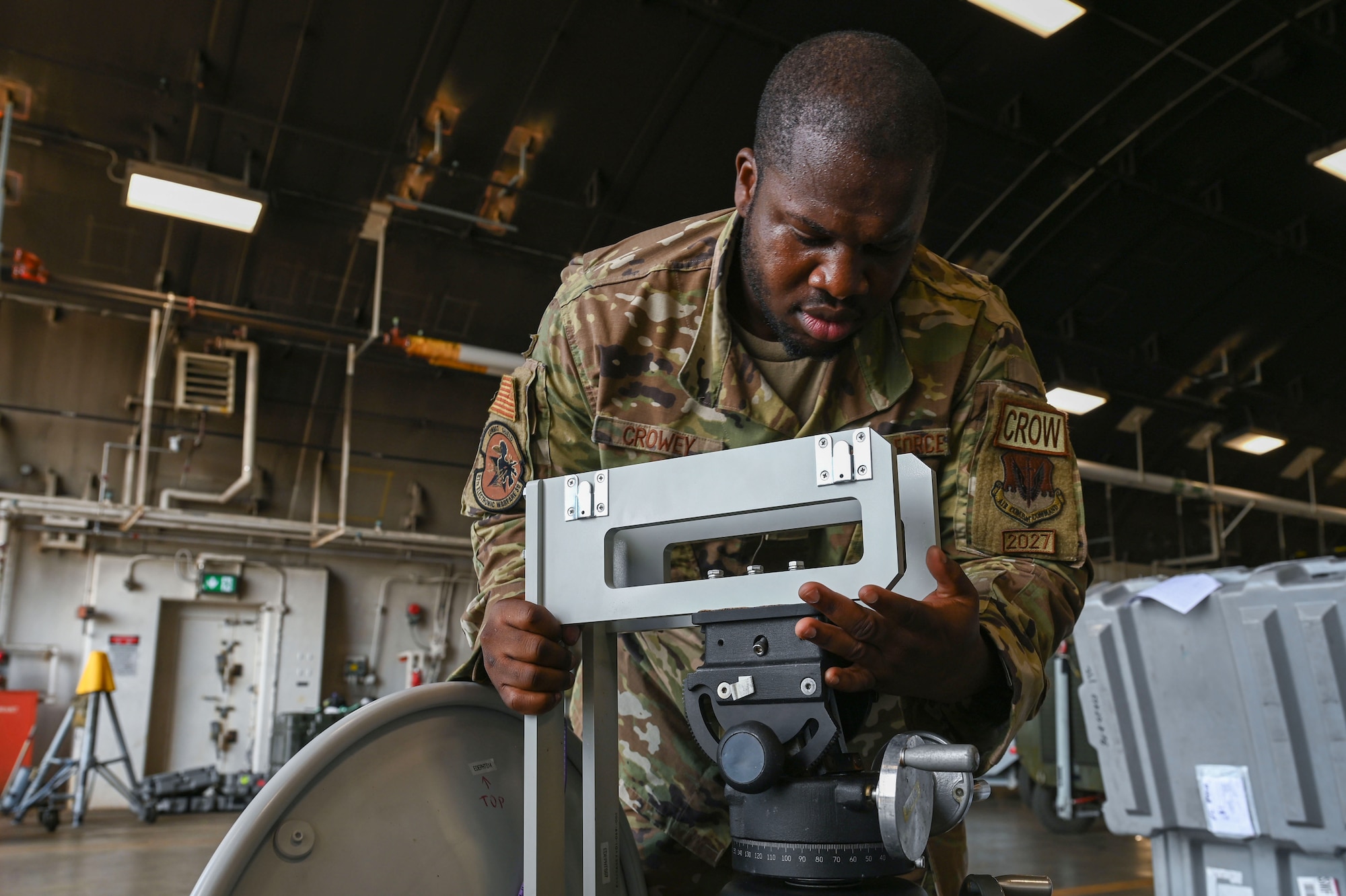 U.S. Air Force Staff Sgt. David Crowey, 87th Electronic Warfare Squadron Combat Shield avionics electronic warfare (EW) technician, connects a parabolic dish to a tripod stand to test the AN/ASQ-213 HARM Targeting Systems at Misawa Air Base, Japan, Aug. 9, 2023. Combat Shield ensured U.S. Air Force air assets at Misawa AB, Japan, have EW combat readiness and are effective to support a free and open Indo-Pacific. (U.S. Air Force photo by Staff Sgt. Ericka A. Woolever)