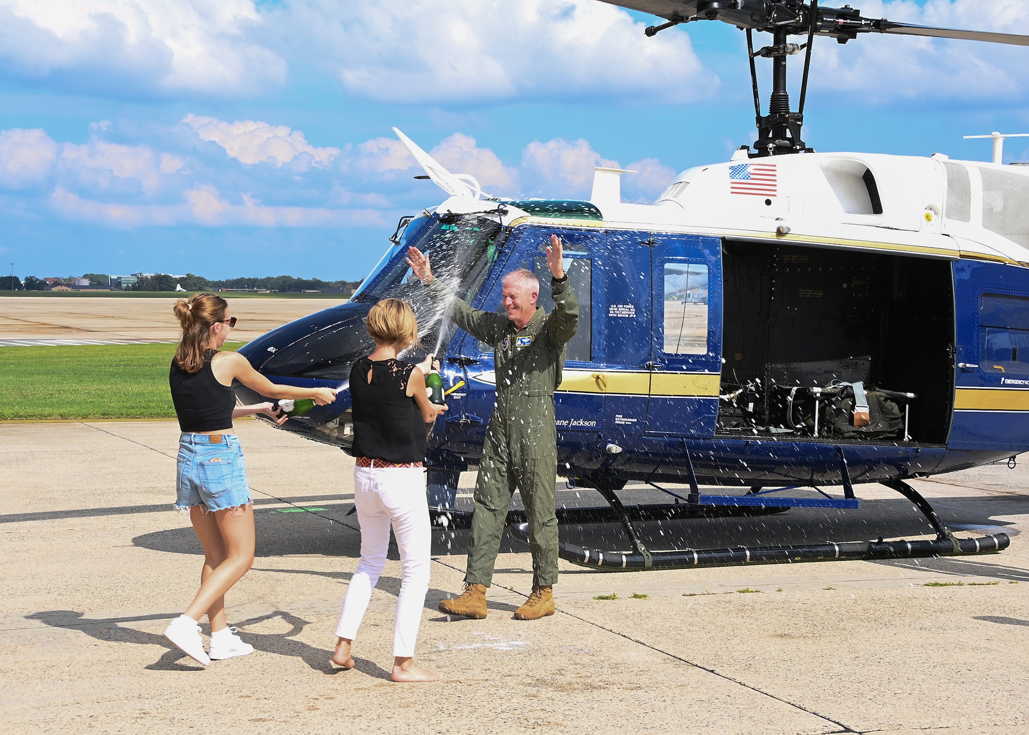 woman spray man in uniform near helicopter