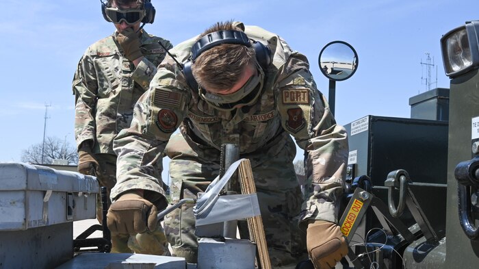 U.S. Air Force Tech. Sgt. Camren Wolfe, 509th Logistics Readiness Squadron, Cargo Deployment Function NCOIC, and U.S. Air Force Staff Sgt. Motsenbocker, 509th Logistics Readiness Squadron, Air Transportation Function supervisor, attach a unit of aerospace ground equipment to a truck at Whiteman Air Force Base, Mo., April 13, 2023. After the Airmen remove the equipment from the C-130 Hercules they attach it to a truck to tow away. (U.S. Air Force photo by Airman 1st Class Hailey Farrell)